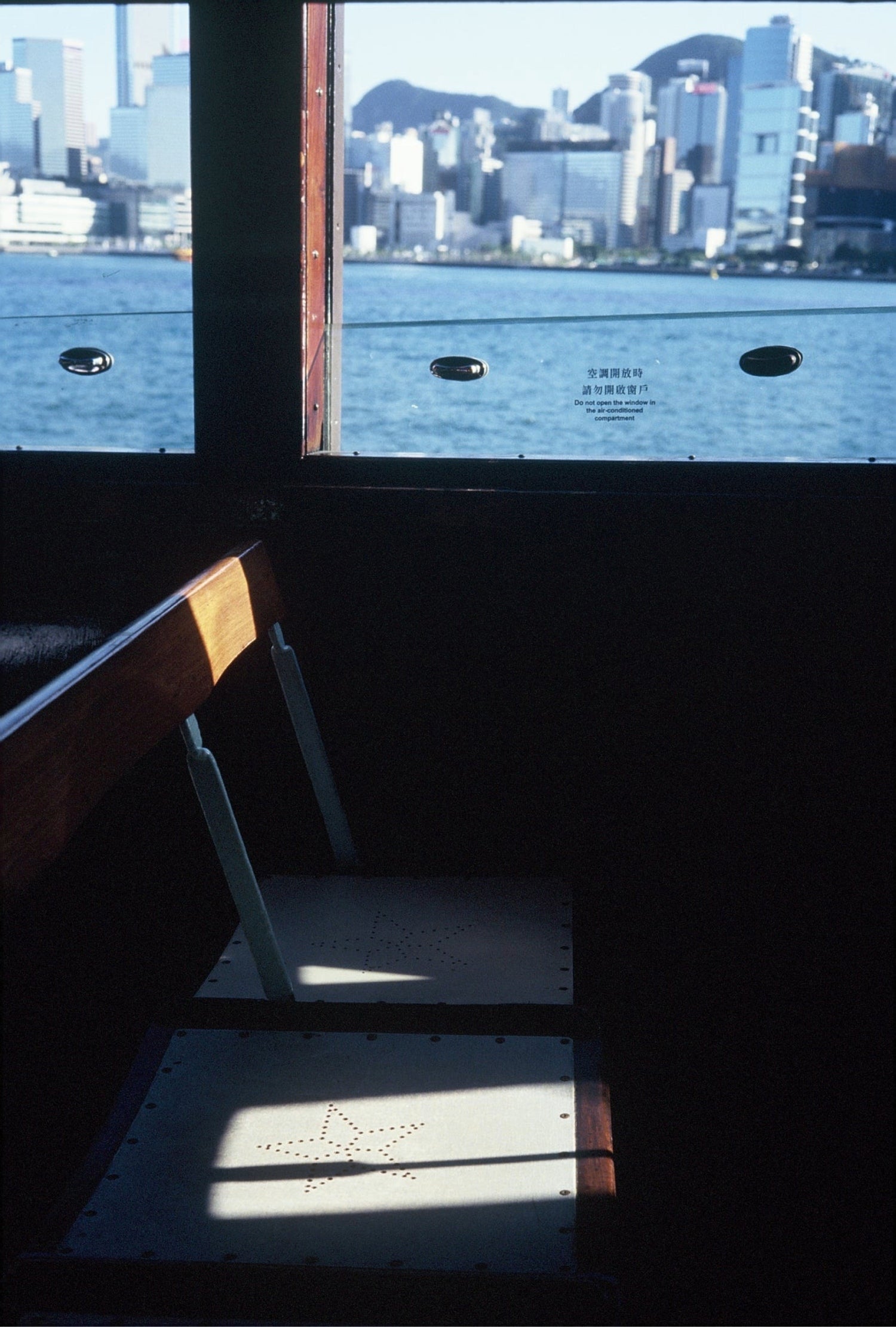 Interior of a ferry with a view of the harbor through the window, captured on KOMICHROME 100 slide film with medium grain.