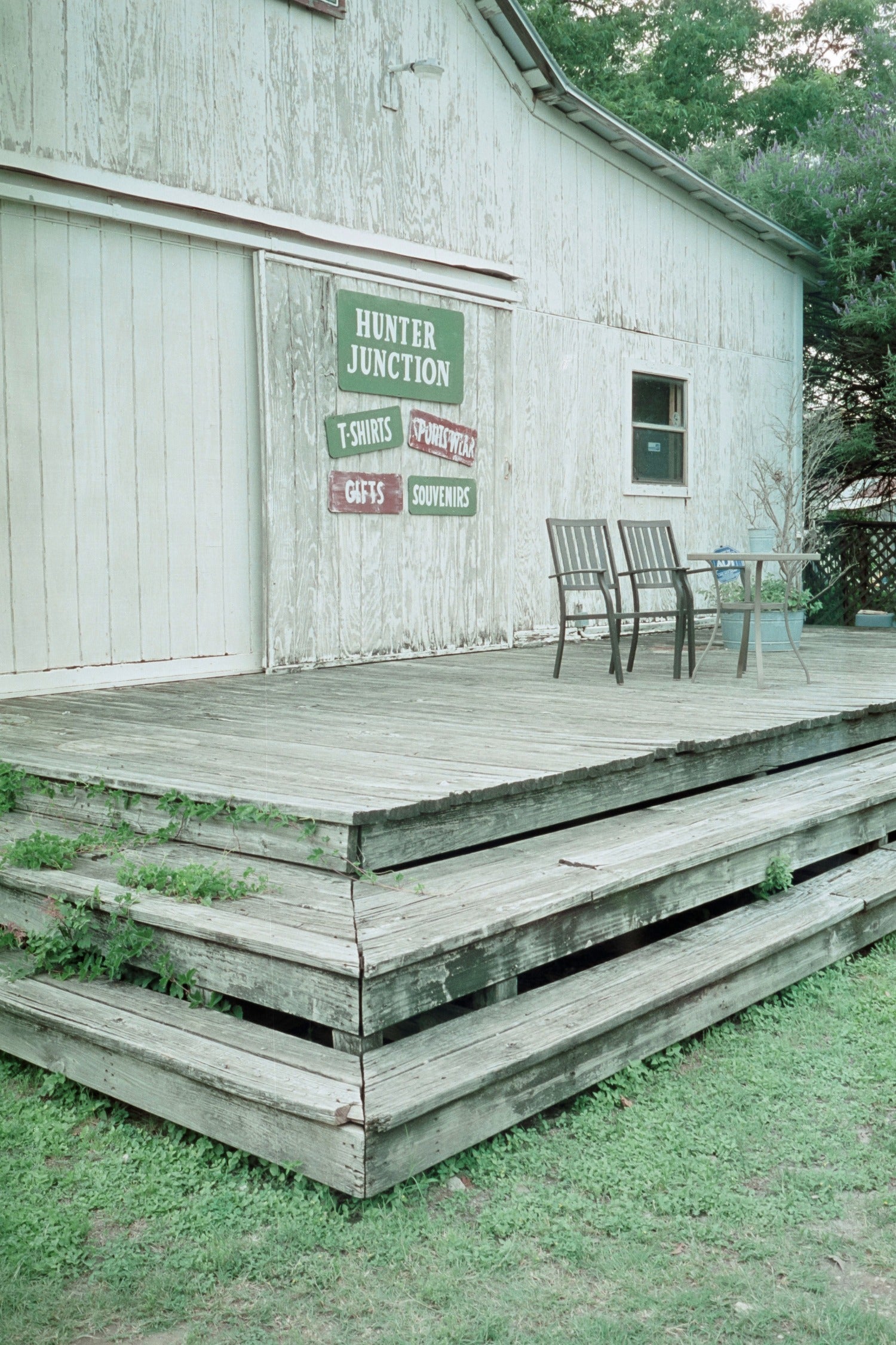 MISO 200 film capturing an old wooden deck in front of Hunter Junction with rustic signage and empty chairs.