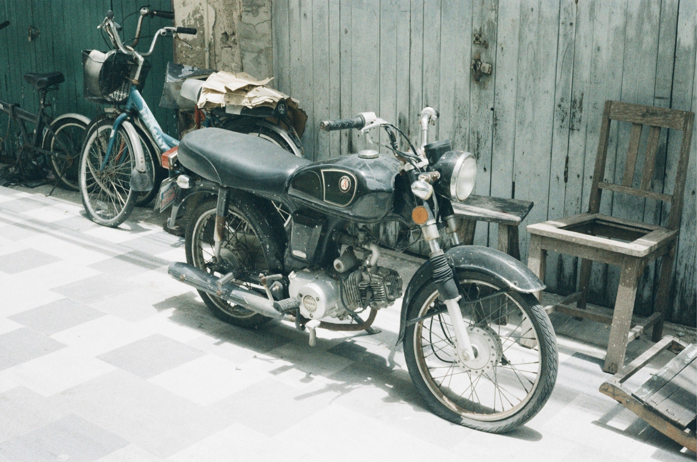 URBAN 400 film photo of an old motorbike on a sidewalk in Bangkok, high grain texture.