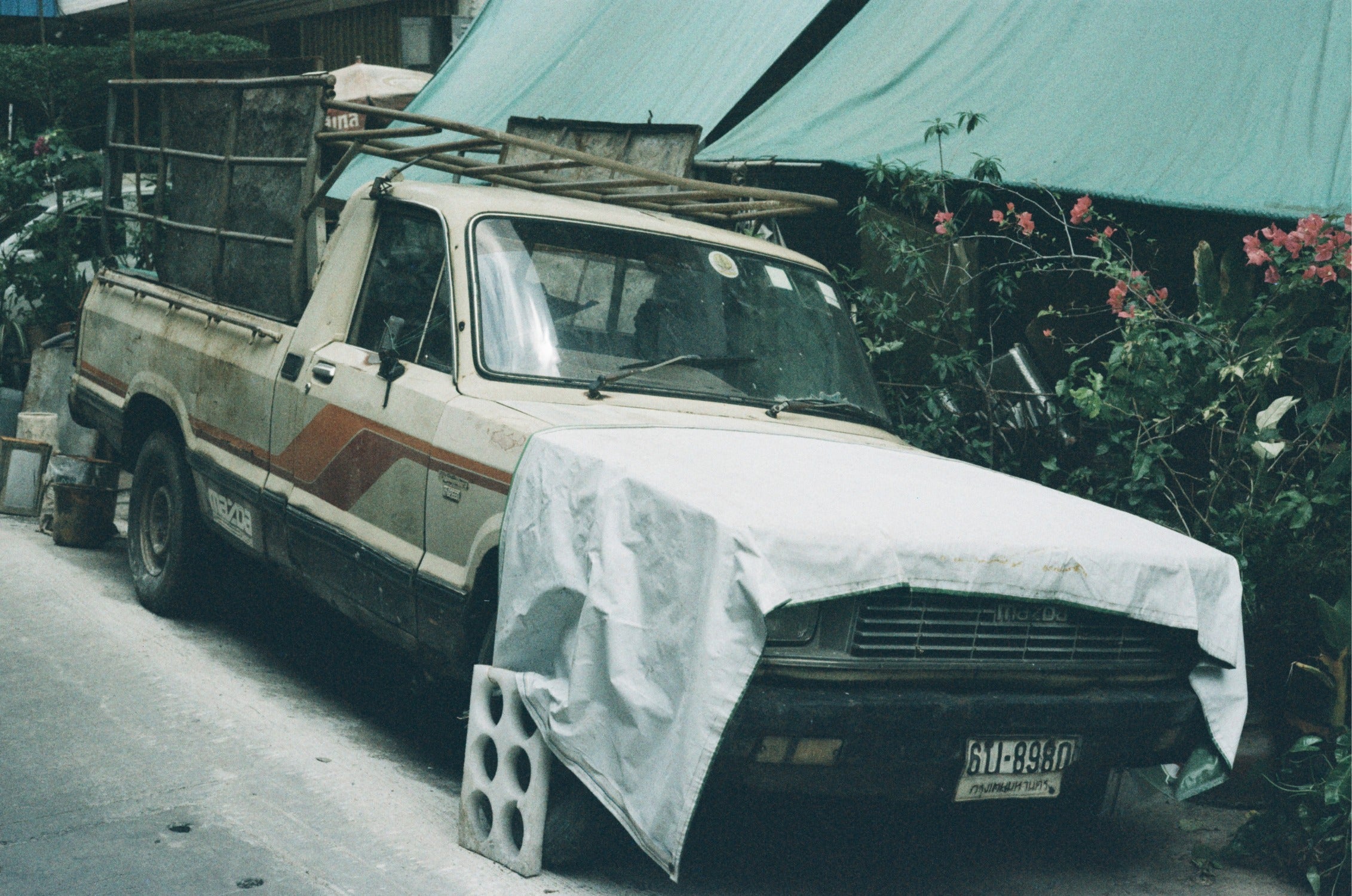 URBAN 400 film photo of an old truck with a canvas cover, high grain texture.